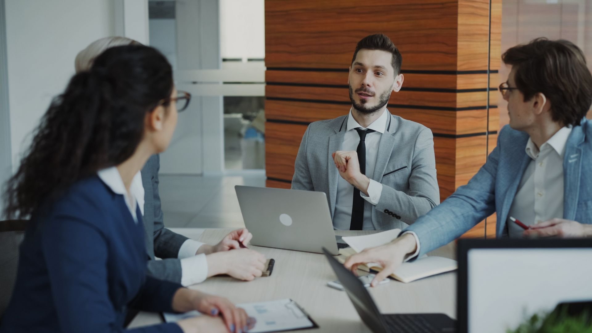 Business team meeting around a conference table with laptops