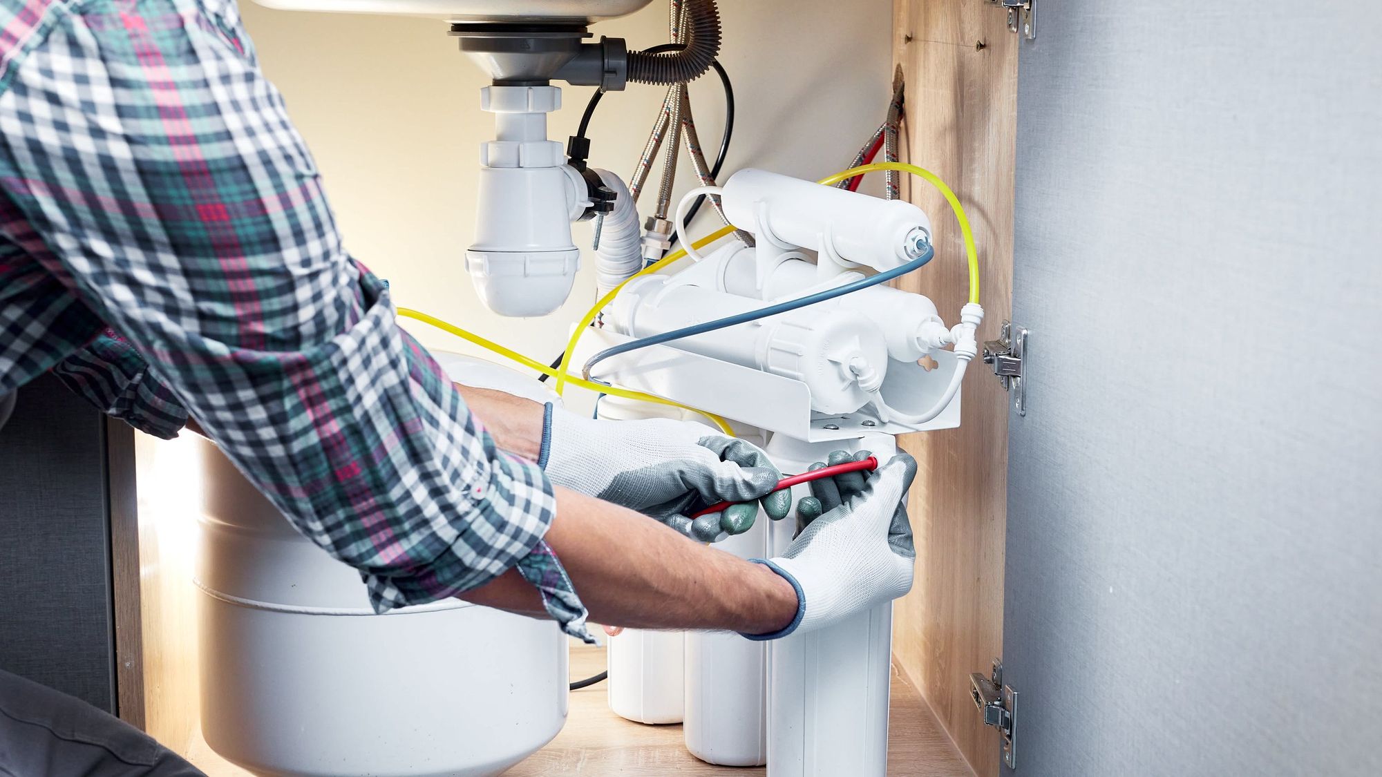 Technician installing an under-sink water filtration system